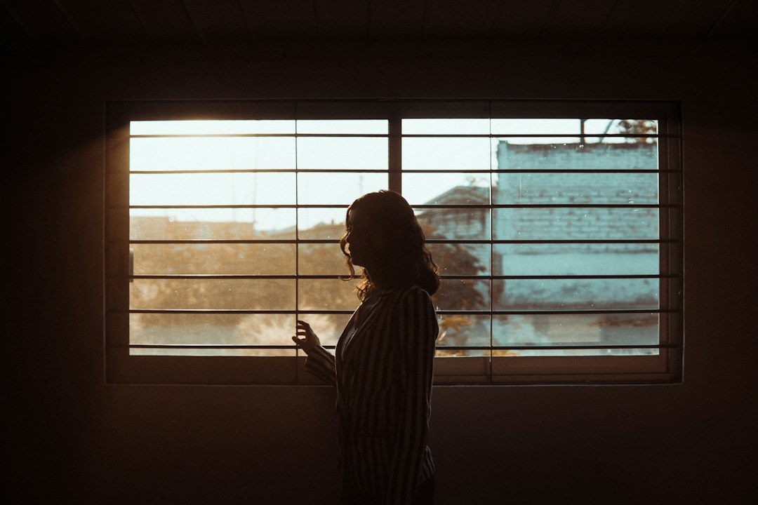 Femme ouvrant une fenêtre pour aérer son intérieur et renouveler l'air de la pièce