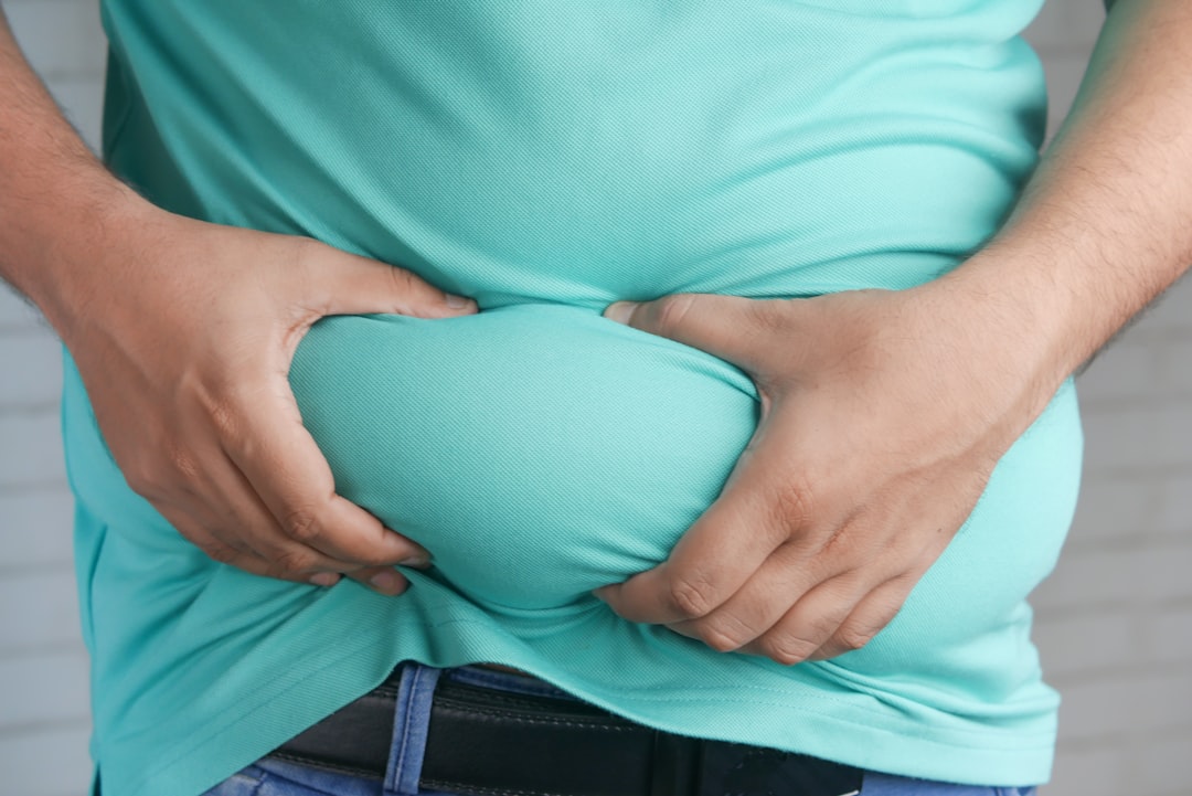 Homme se tenant l'estomac, une sensation de brûlure qui peut révéler un reflux gastro-œsophagien