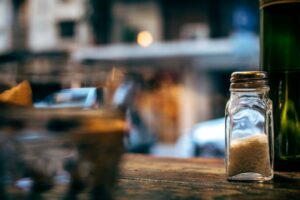 Salière sur une table, le sel caché dans l'alimentation est l'une des habitudes qui augmentent la tension artérielle