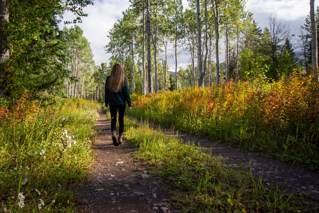 Femme marchant sur un chemin en pleine nature, une activité quotidienne associée à un risque réduit de cancer