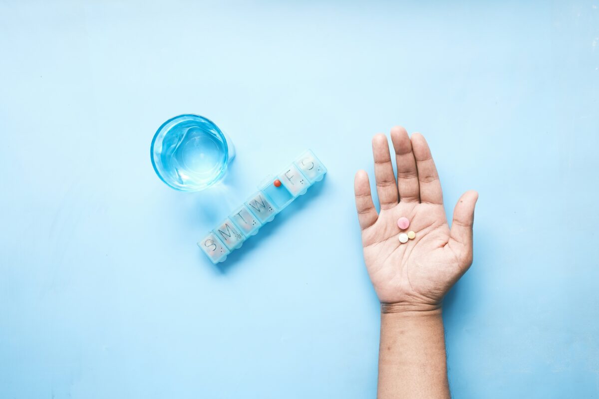 Boîte de comprimés de paracétamol et verre d'eau, illustrant les risques du surdosage de paracétamol pour le foie