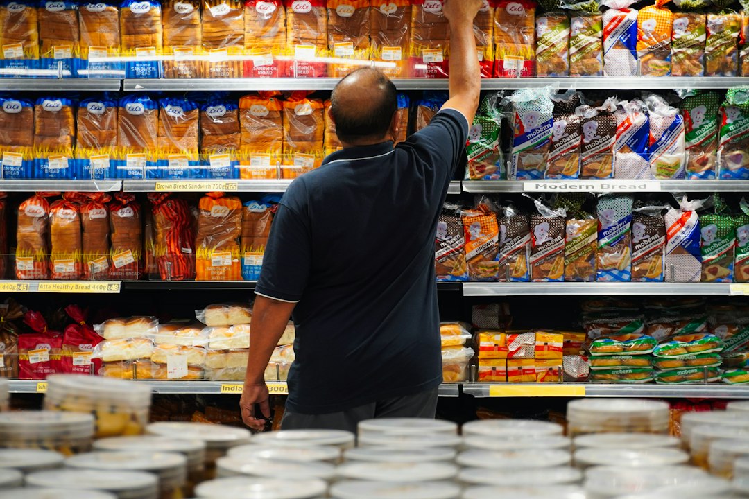 Homme prenant du pain en rayon, un aliment ultra-transformé se repère souvent avant même de lire l'étiquette