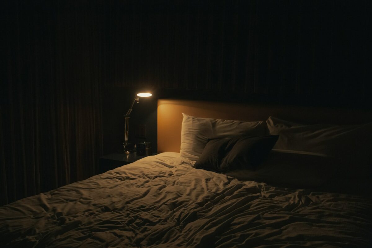 Apnée du sommeil : lampe de chevet allumée près d’un lit dans une chambre