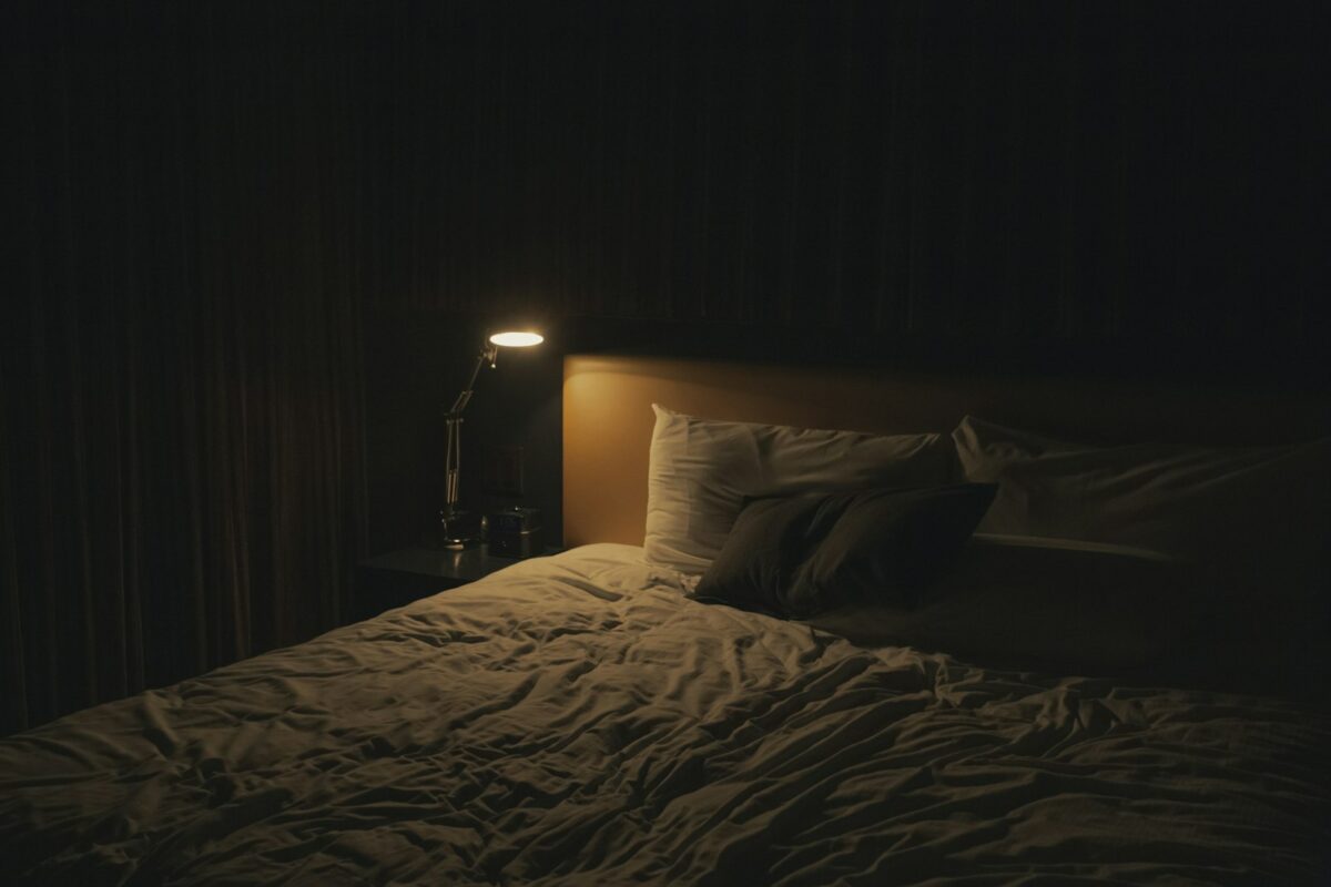 Bruxisme nocturne : chambre calme avec lampe de chevet allumée près du lit
