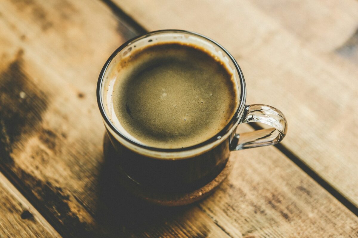Trop de caféine : une tasse de café noir sur une table en bois