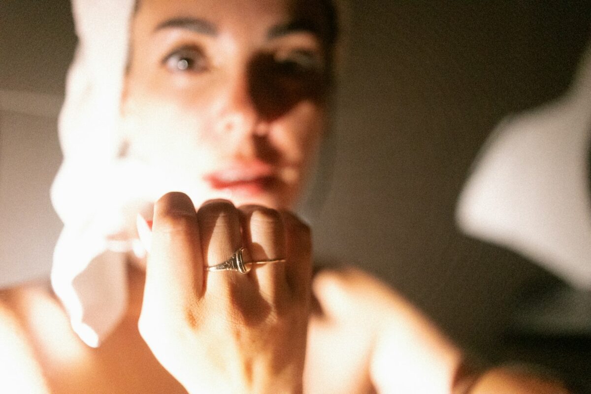 Femme face à son miroir le matin, routine des cuillères glacées pour décongestionner les yeux