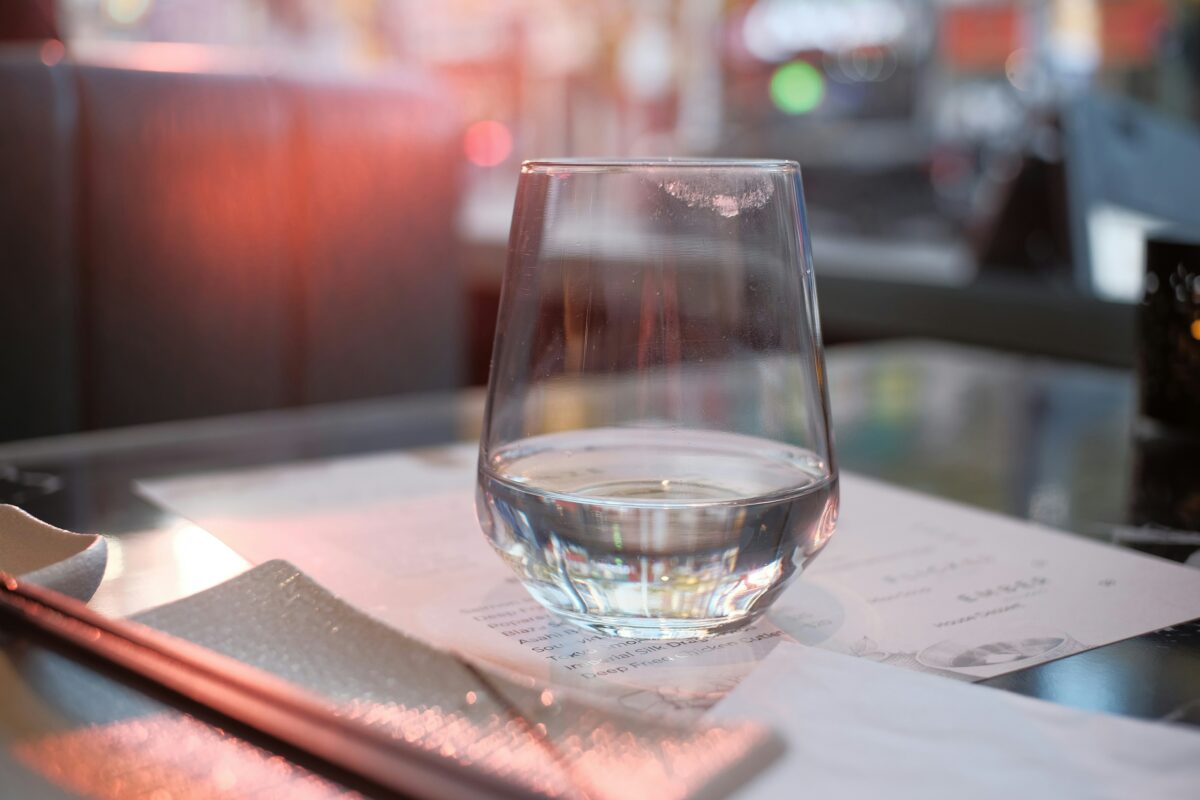 Verre d'eau posé sur une table, illustration de l'eau glacée aux repas