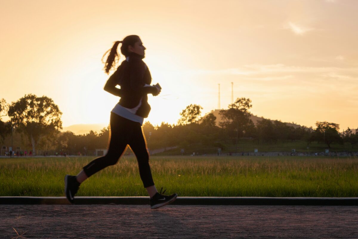 Effet afterburn : une coureuse s'entraîne sur une piste au coucher du soleil