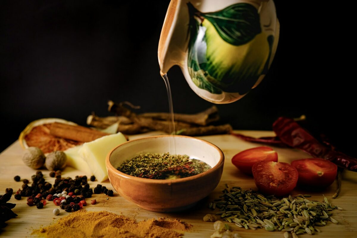 Huile d'olive extra-vierge versée sur des herbes dans un bol