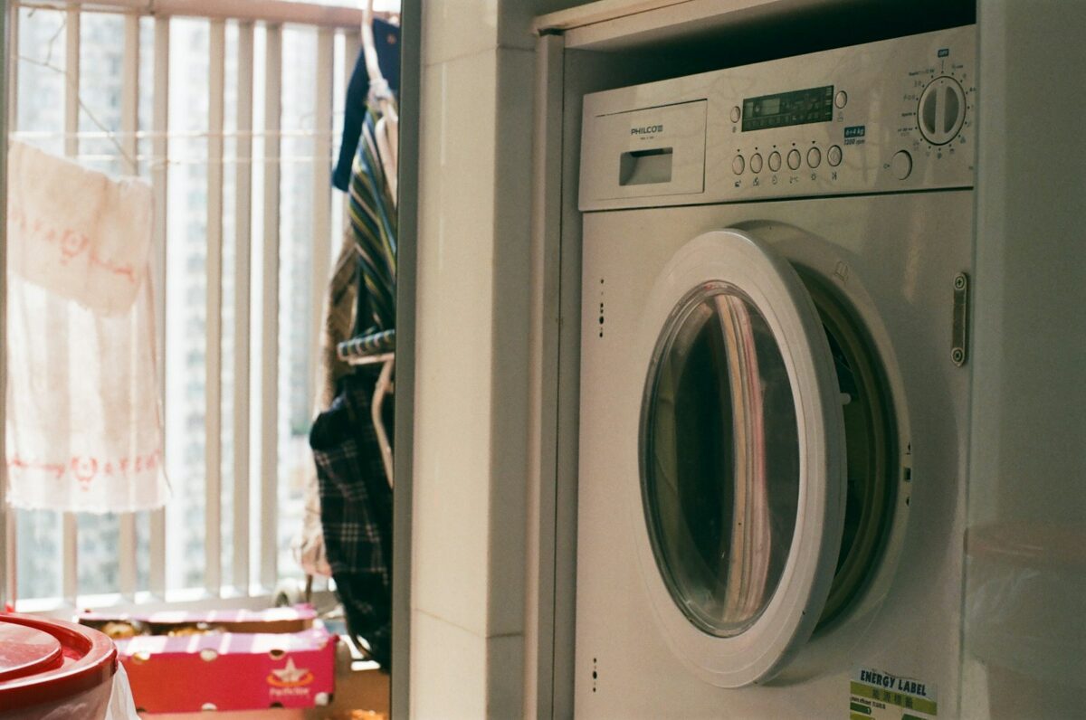 Joints de lave-linge moisis : lave-linge à hublot blanc dans une buanderie