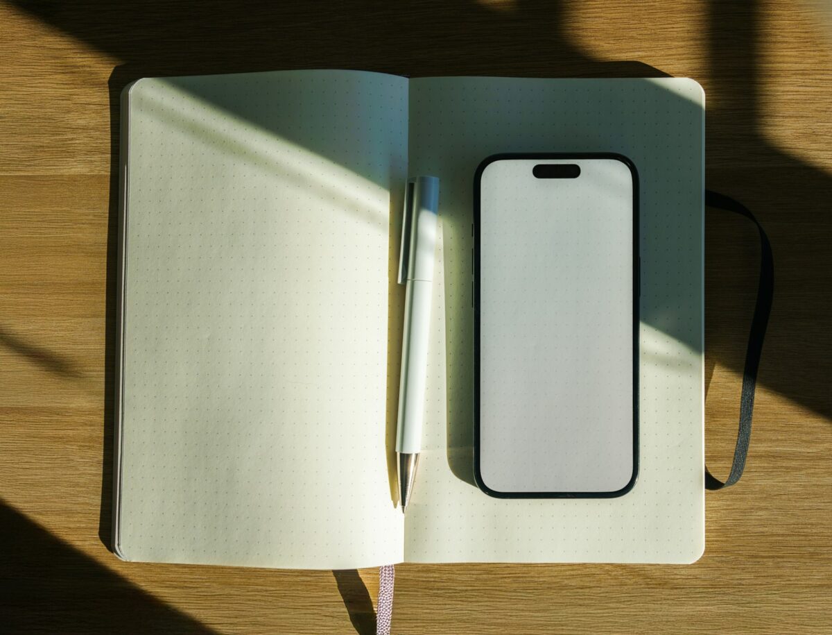 Minimalisme numérique : smartphone et carnet sur un bureau en bois