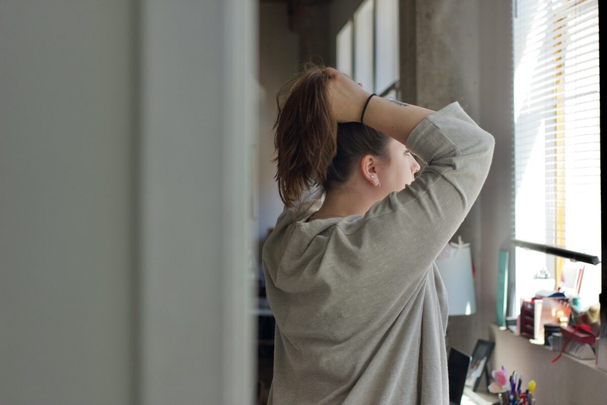Femme au bureau portant la main à la nuque raide après des heures devant l'écran