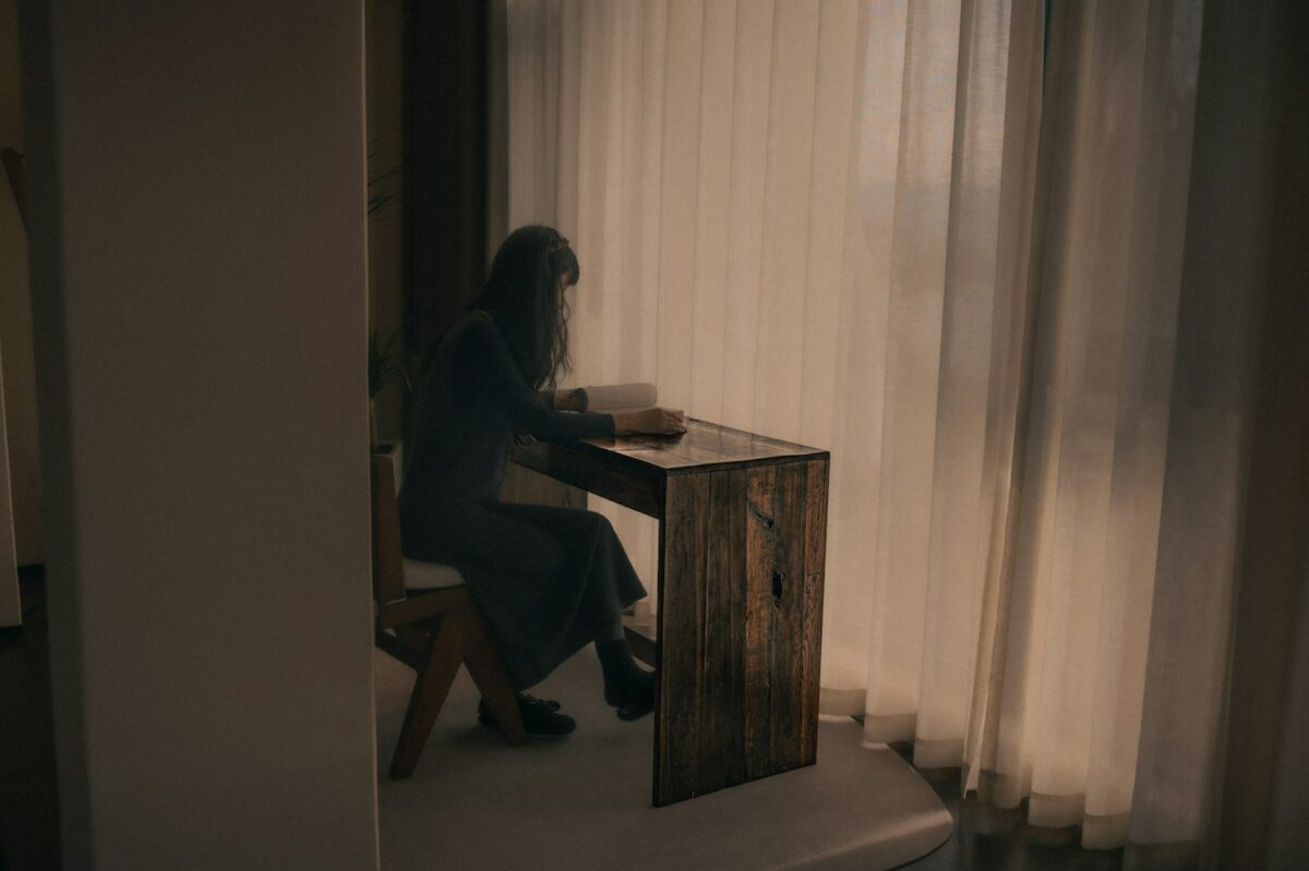 Perfectionnisme toxique : une personne assise à son bureau près d'une fenêtre