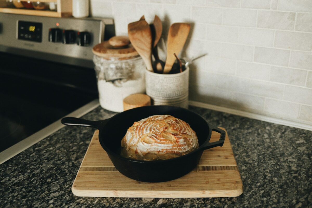 Poêle en fonte culottée posée sur une planche en bois dans la cuisine