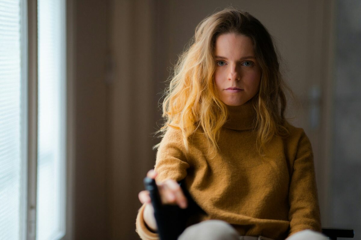 Femme assise près d'une fenêtre dans la lumière, un moment calme pour poser des limites