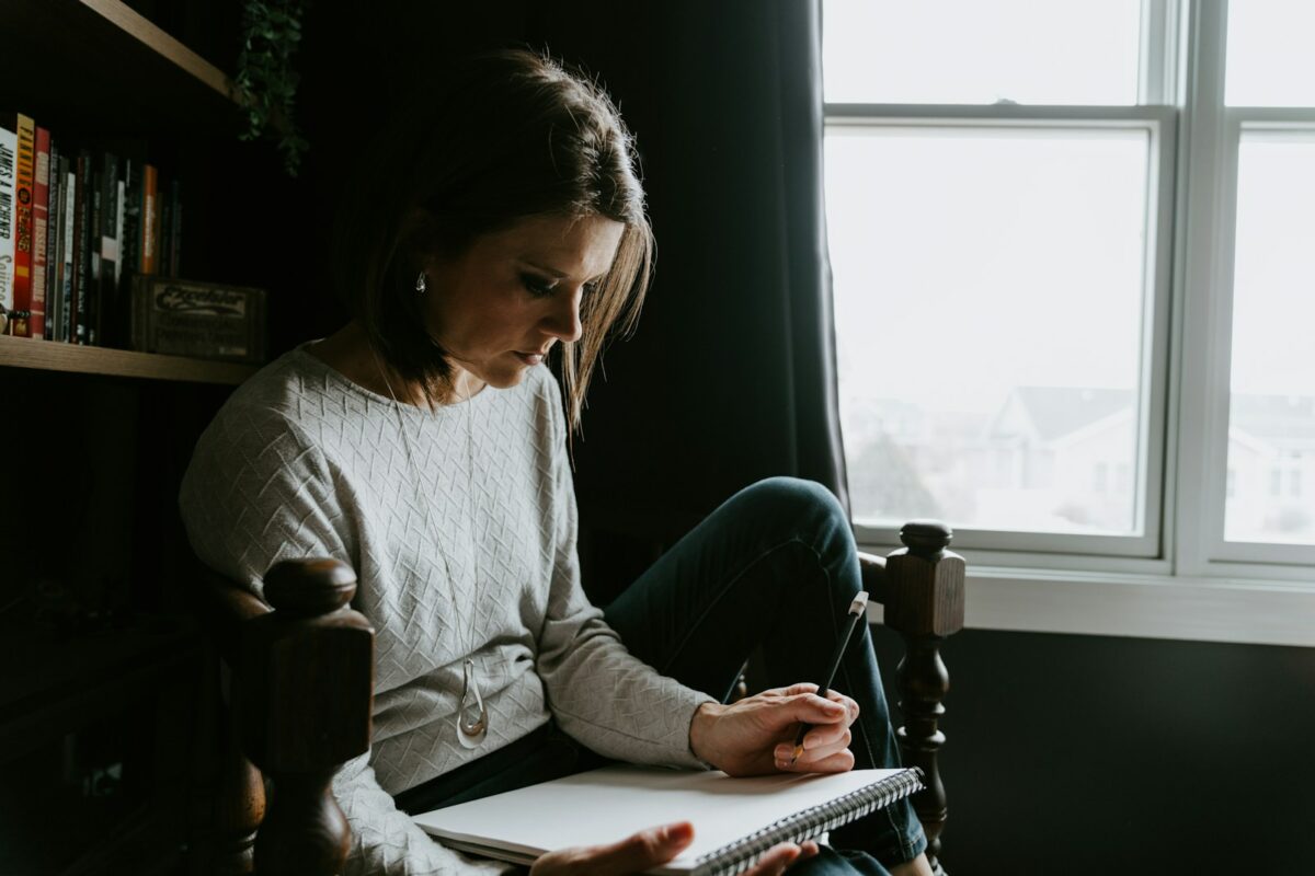 Positif toxique : une femme note ses émotions dans un carnet, sans se forcer à aller bien