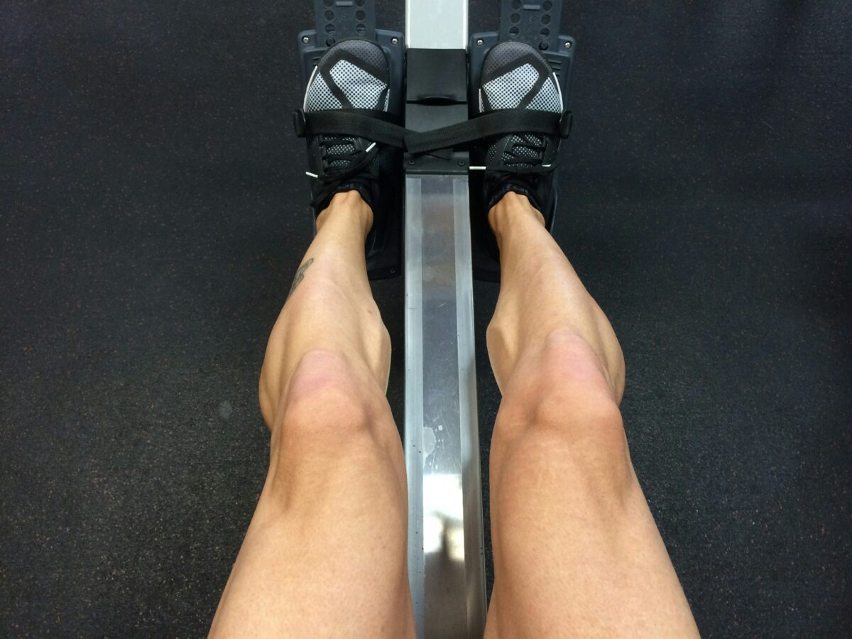 Personne assise sur un rameur en salle de sport