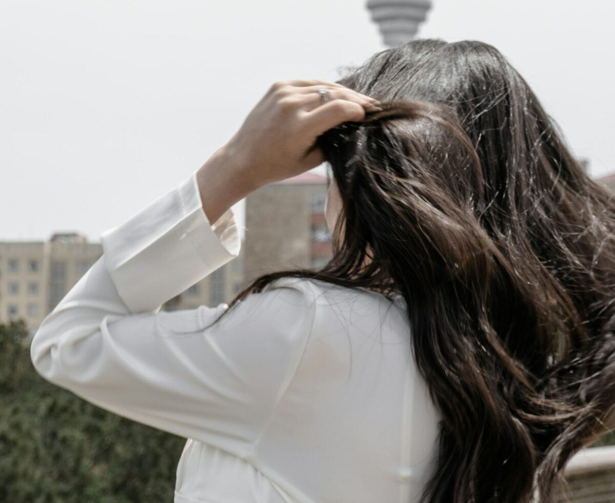 Shampoing sans sulfates : femme aux longs cheveux bruns en lumière naturelle