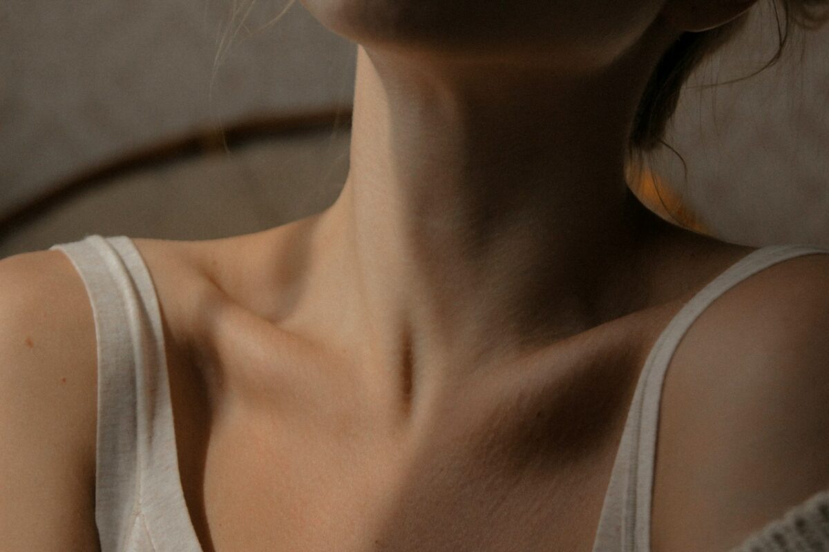 Femme au cou dégagé, geste de soin pour un massage lymphatique du cou