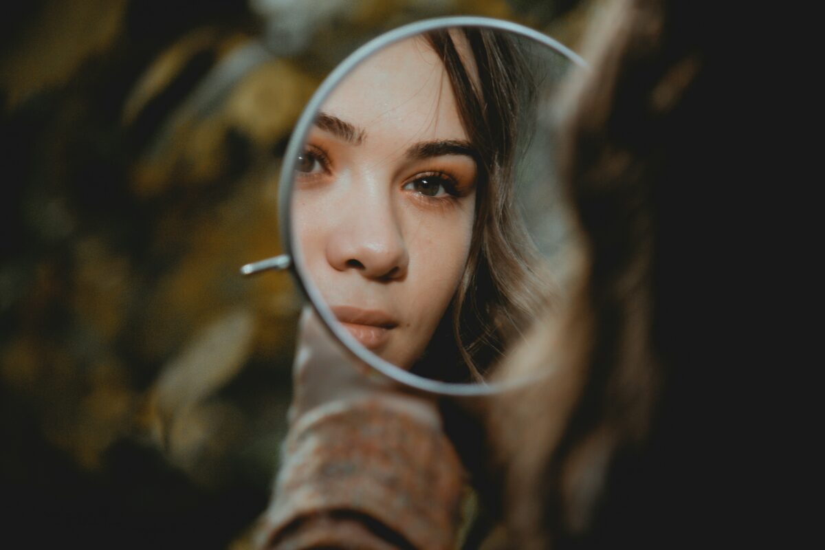 Yoga du visage : femme qui se regarde dans un petit miroir